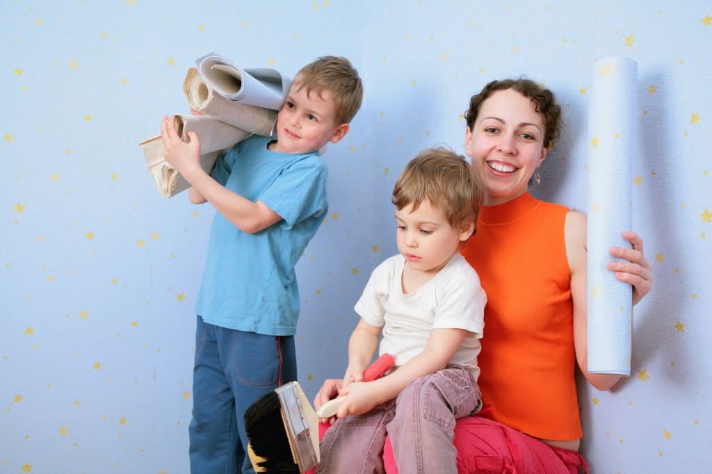 Children help mothrer to glue wall-papers