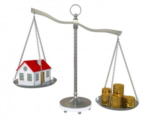 House and gold coins on the scale
