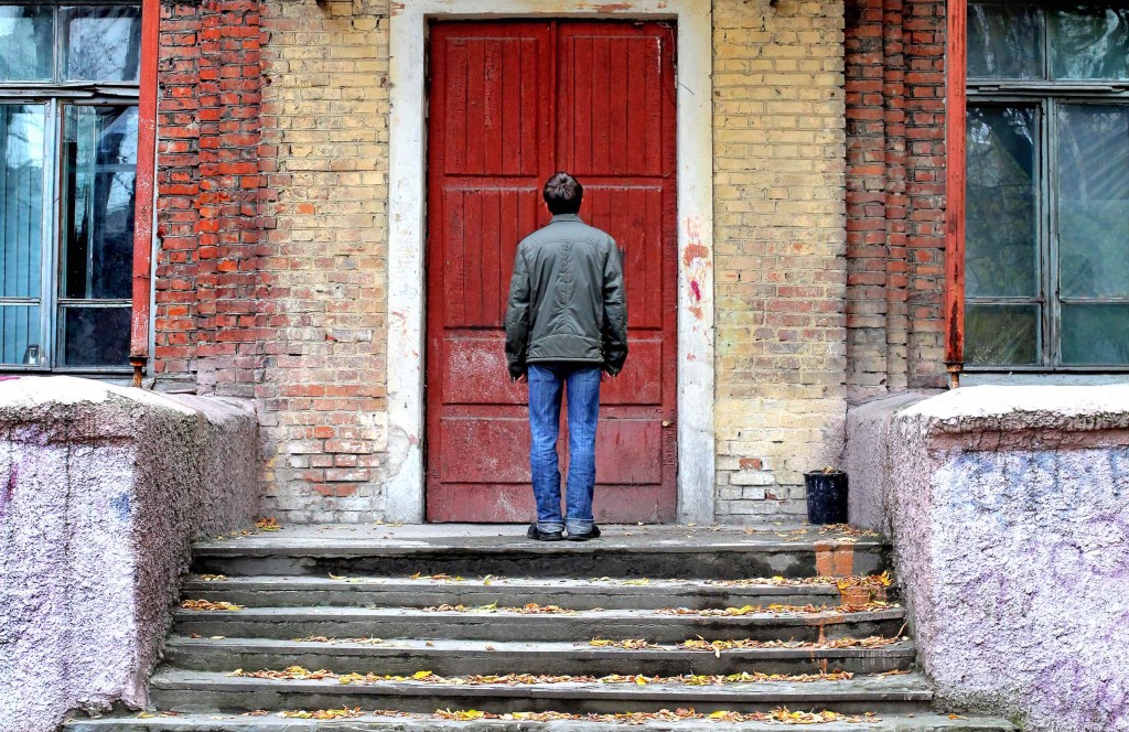 Man in Front of the Old House before the Closed Door