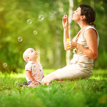 mother-and-baby-blowing-bubbles-outside_web
