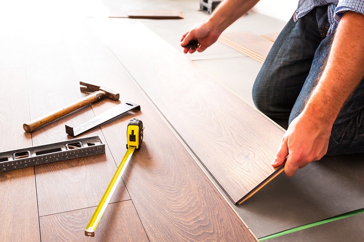 Man installing new laminated wooden floor