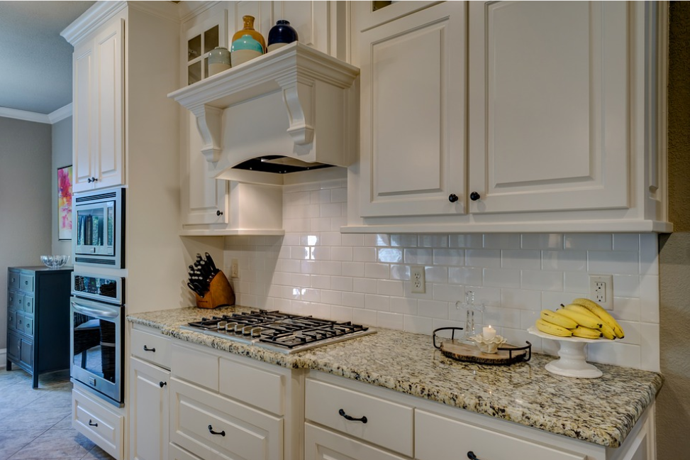 kitchen with white brick tiles and cream cabinets