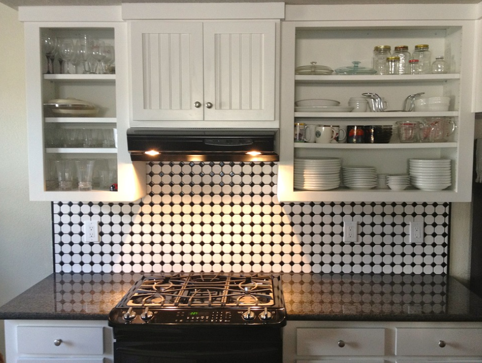kitchen with black and white tiles black counter and white cabinets