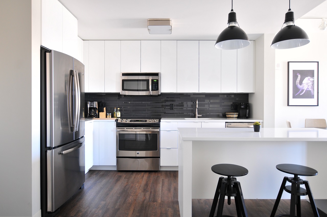 white kitchen counter cabinets walls with black stools and lights