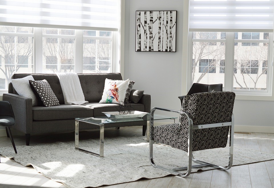grey scale living room with couch chair table art windows