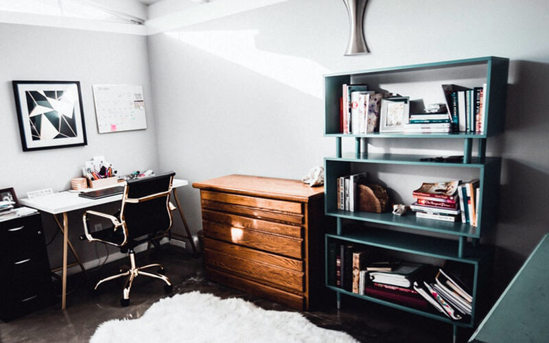 Spare Space turned into Home Office home office with white desk, black chair, white rug, cabinet, shelves